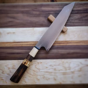 Gyuto kirisuke damasco encabado en varias maderas, nogal español, arce duro, nogal americano y unos detalles de abedul y roble blanco. La hoja es de , núcleo central de VG10 y 32 capas de damasco a cada lado. Una hoja muy versátil y cómoda en la cocina occidental y, aún siendo una hoja tradicional japonesa, se ha adoptado perfectamente en la cocina tradicional nuestra. Muy elegante y bonita, está pieza es un capricho para cualquier cocina.