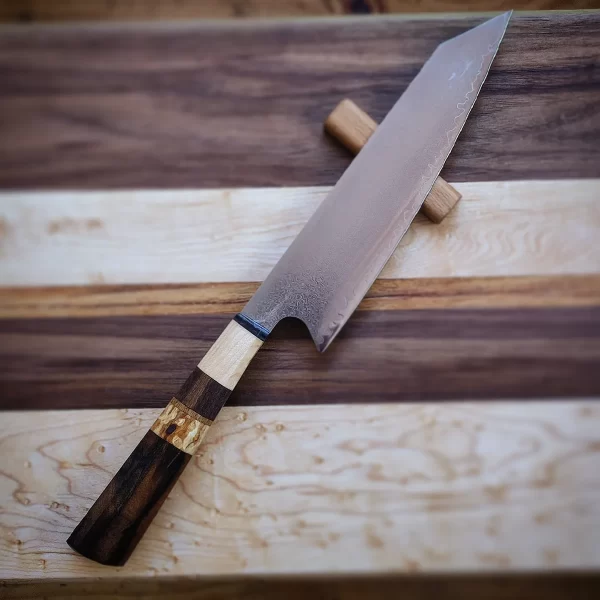 Gyuto kirisuke damasco encabado en varias maderas, nogal español, arce duro, nogal americano y unos detalles de abedul y roble blanco. La hoja es de , núcleo central de VG10 y 32 capas de damasco a cada lado. Una hoja muy versátil y cómoda en la cocina occidental y, aún siendo una hoja tradicional japonesa, se ha adoptado perfectamente en la cocina tradicional nuestra. Muy elegante y bonita, está pieza es un capricho para cualquier cocina.